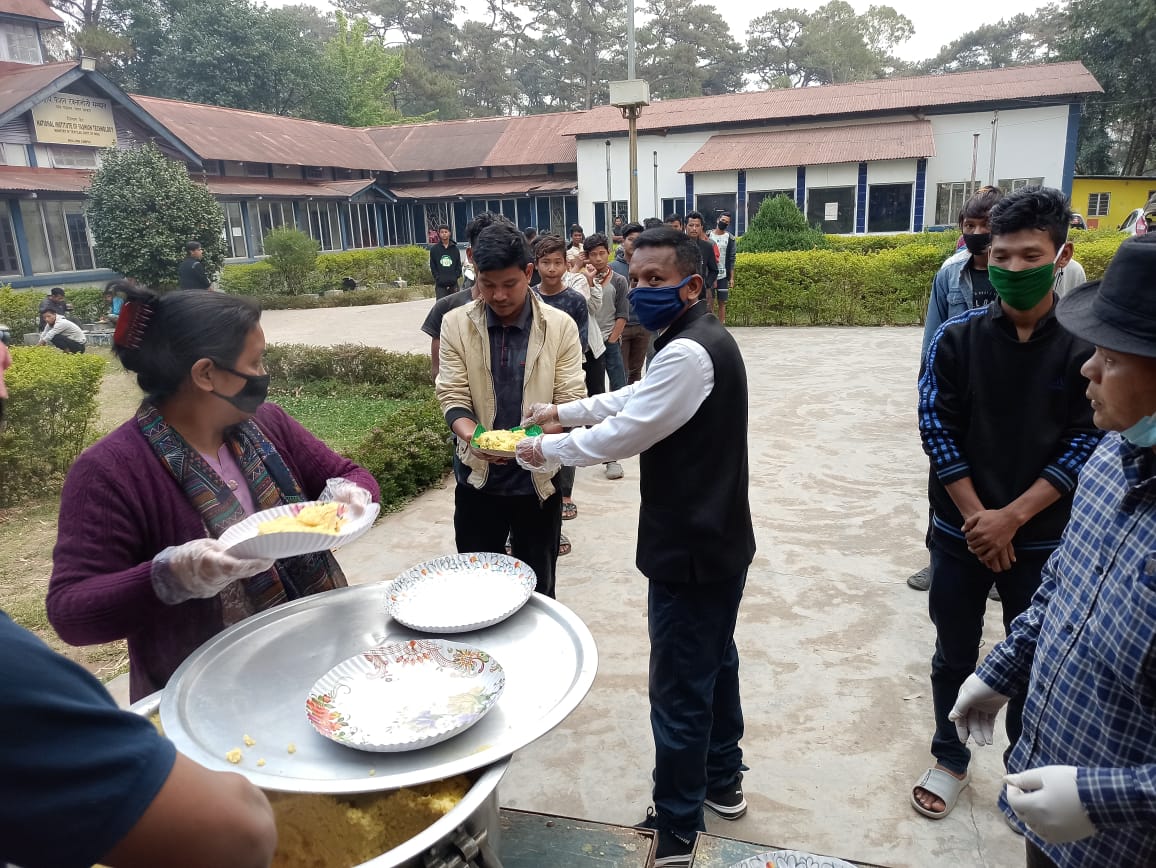 Serving meals to a line of people.