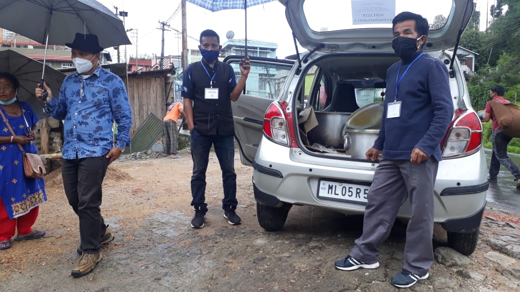 Preparing to distribute food from a car in the rain.