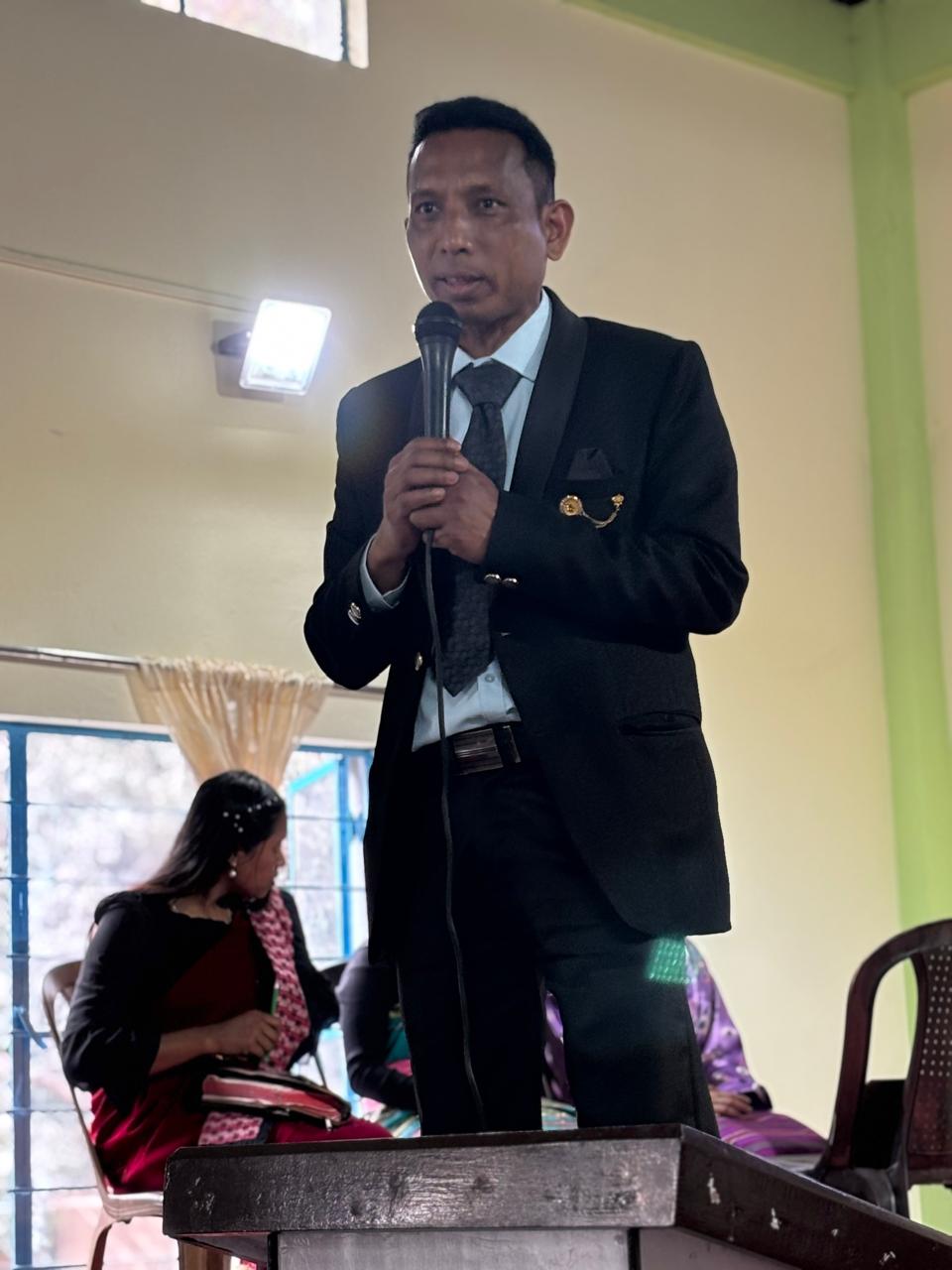 Speaking into a microphone at a pulpit.