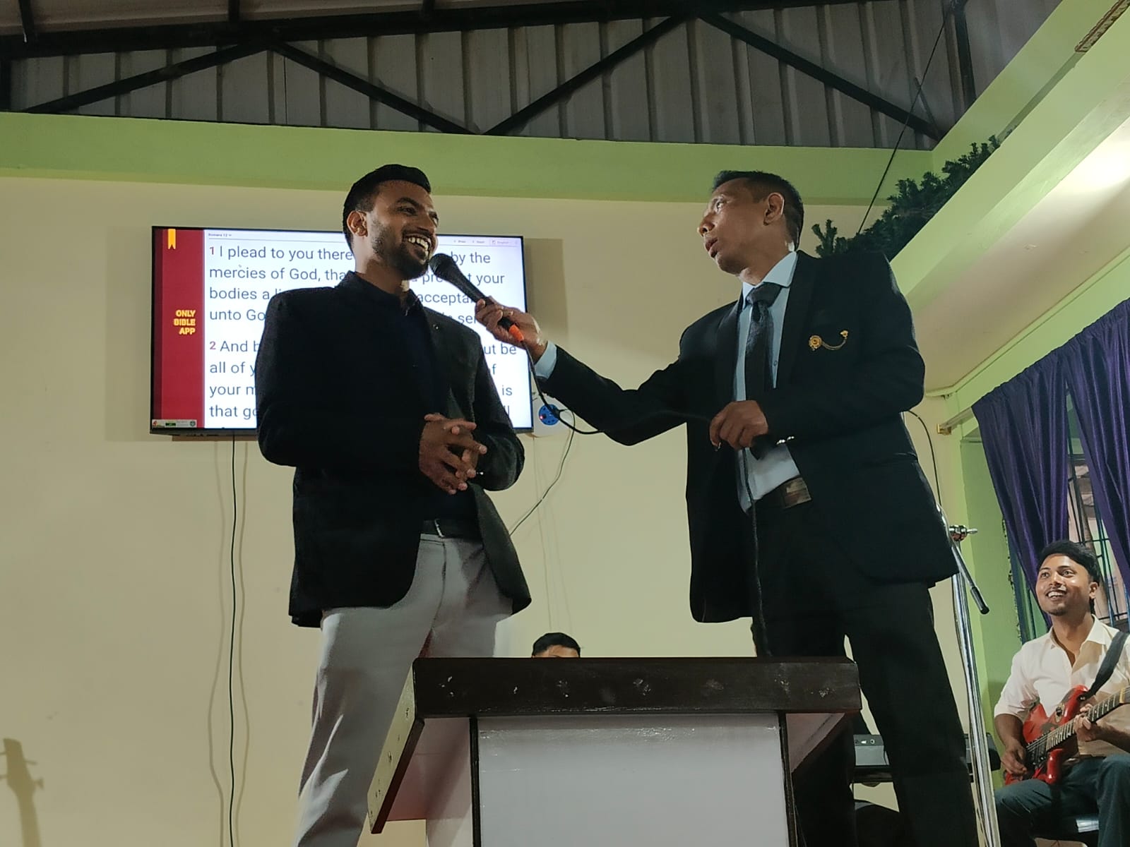 Sharing the microphone with a guest on stage.