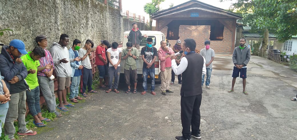 Leading a group of men in prayer.