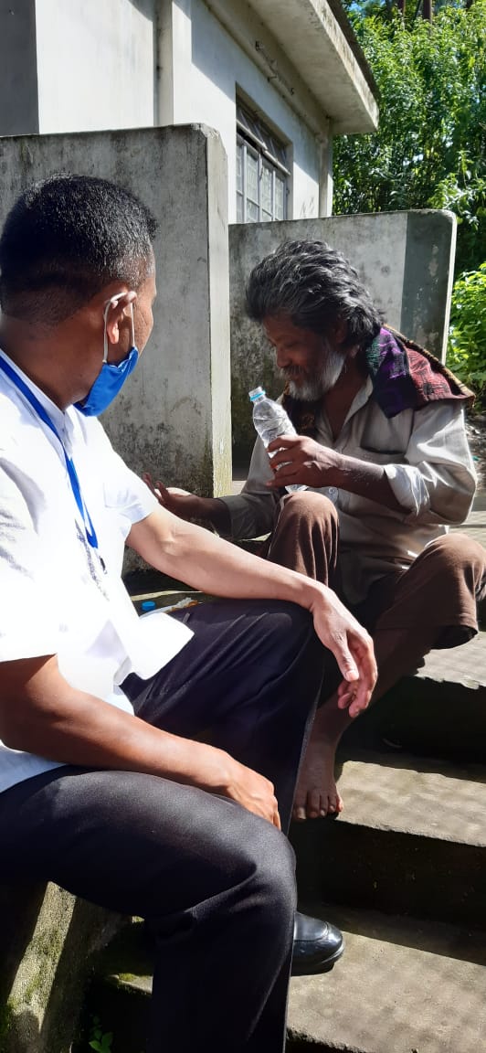 A team member offering comfort and water to a man.